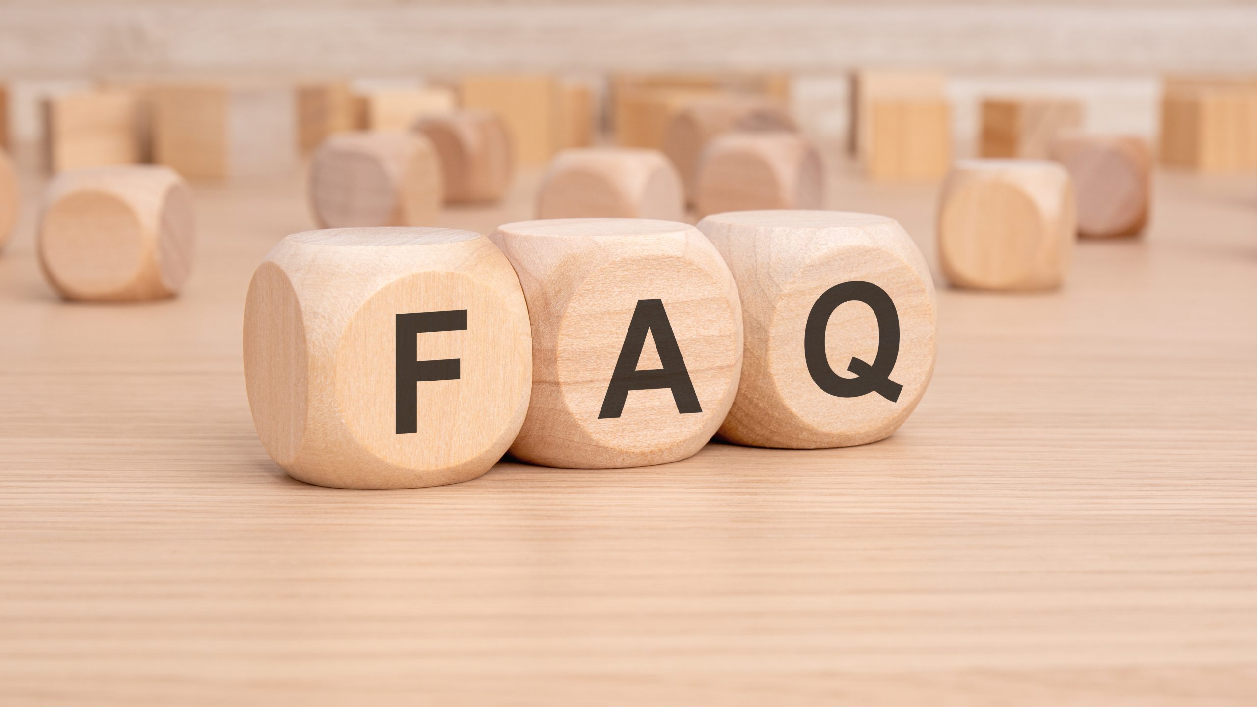 FAQ blocks on a smooth oak hardwood floor-style worktop surface, illustrating common Worktop Refinishing questions for homes in Gants Hill.